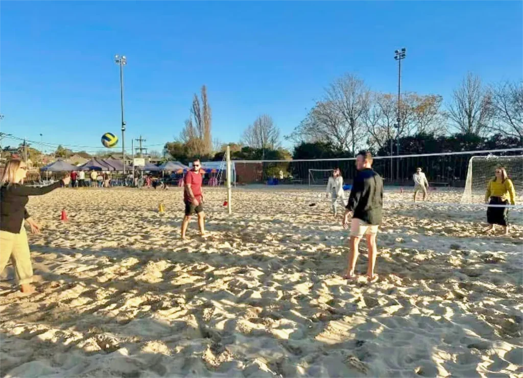 Adults having a fun time at their Beach Party playing Volleyball.