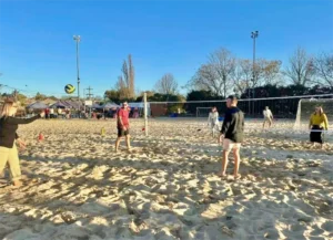 Adults having a fun time at their Beach Party playing Volleyball.