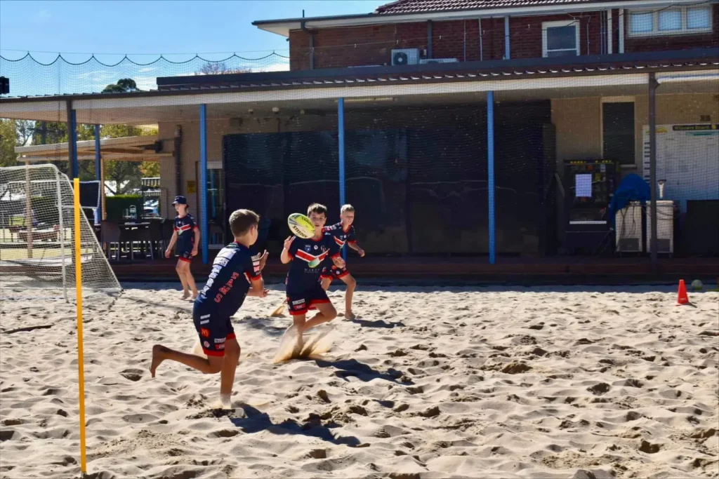 Football team doing a Beach Footy training session.